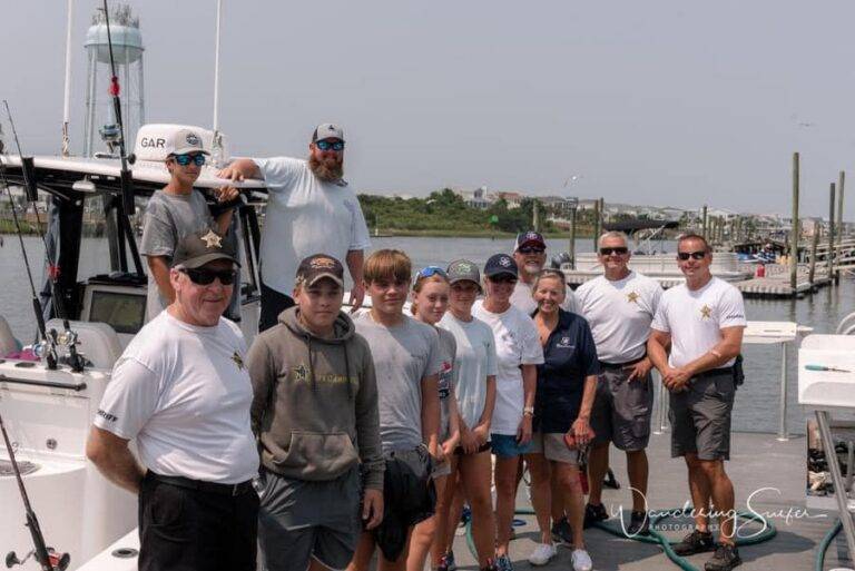Sheriff's deputies and CFH mentors with young people aboard a boat during a CFH outing.