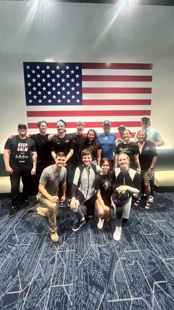 CFH team members and NextGen athletes gathered beneath an American flag.