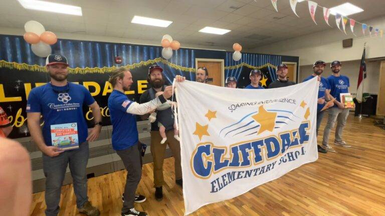 Children of Fallen Heroes volunteers holding a Cliffdale Elementary School banner