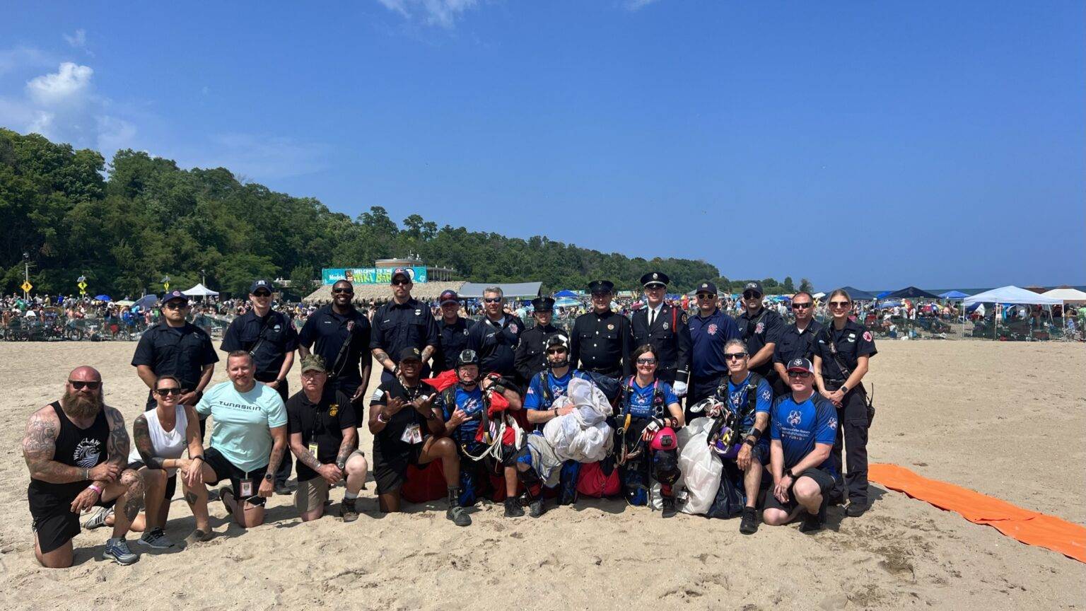 Children of Fallen Heroes youth and families with first responders and CFH Parachute Team members on the beach following a demonstration jump