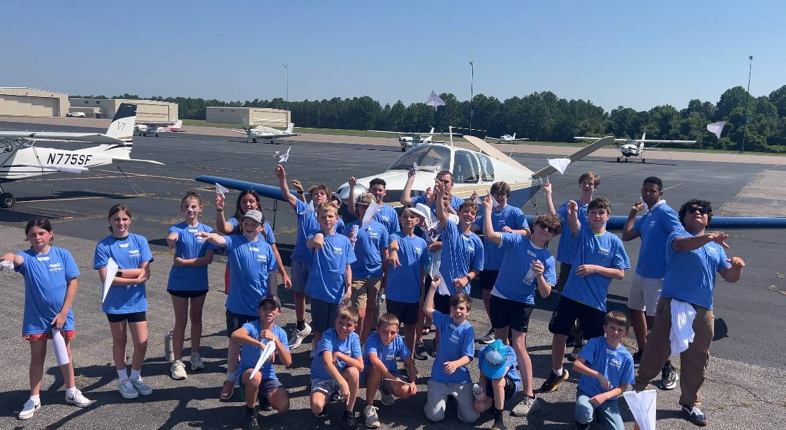 Children standing beside an aircraft