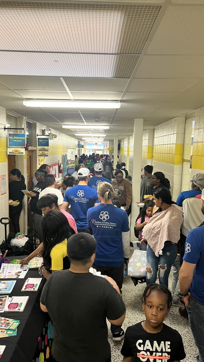 Students, families and Children of Fallen Heroes volunteers filling a school hallway.