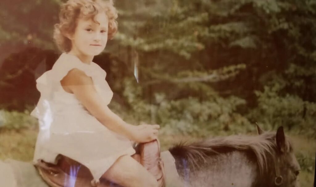 Linda Plummer as a young girl sitting on a horse.