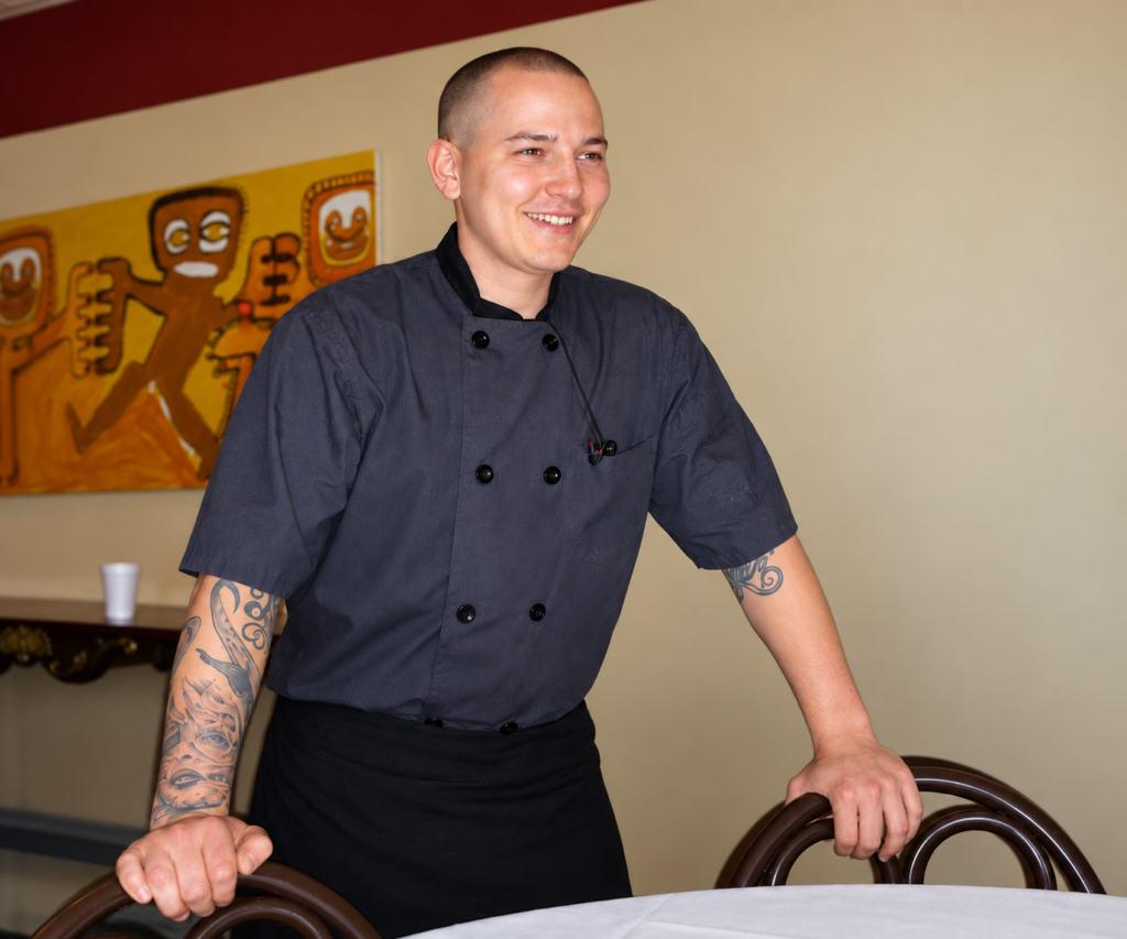 Dylan in his chef's jacket at work in the restaurant where he built his culinary career.