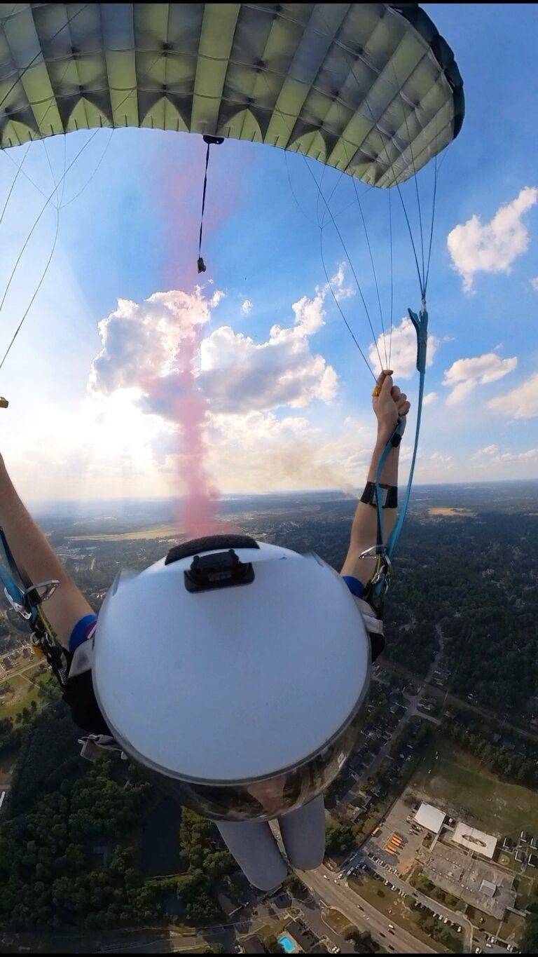 CFH Parachute Team member under canopy with red smoke over Cliffdale Elementary, Fayetteville, NC