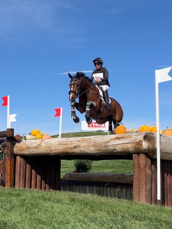 Horse and rider mid-jump over a log fence at the Maryland 5 Star.